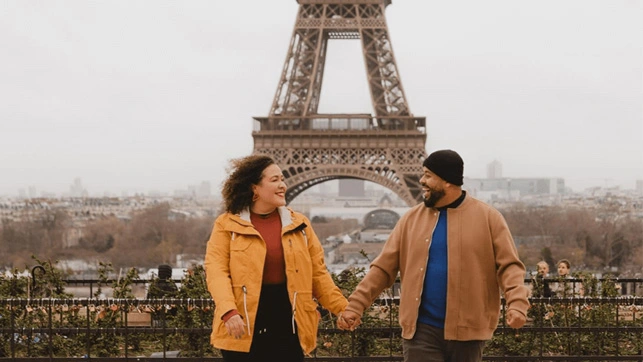 Pati e Jairo de mãos dadas em frente à torre Eiffel em Paris, França